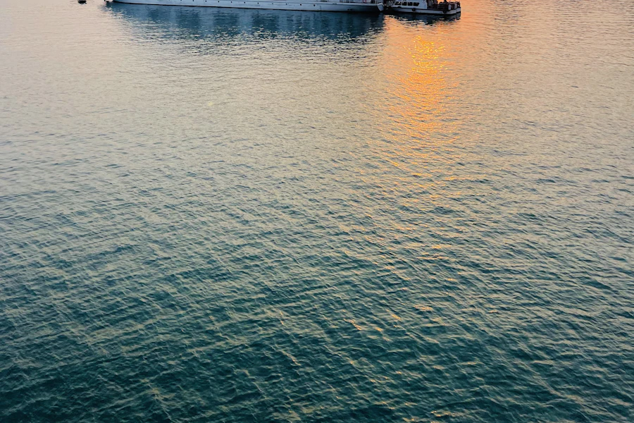 Un bateau de croisière dans la baie d'Along, soleil bas sur l'horizon