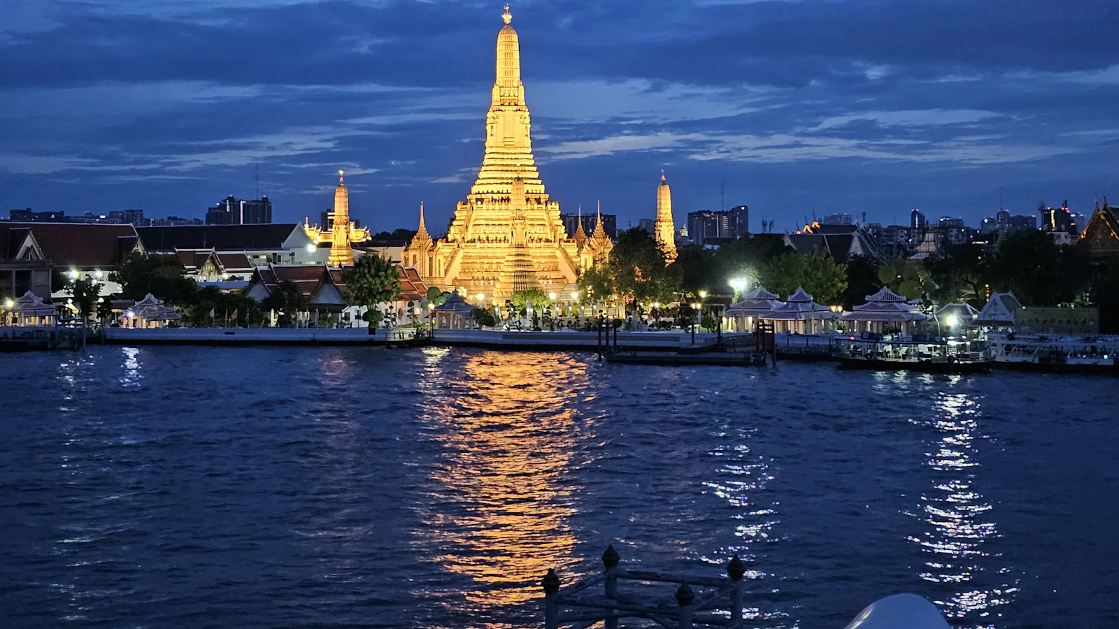 Le Wat Arun illuminé au coucher du soleil, au bord du fleuve Chao Phraya