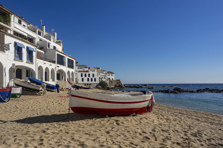 Une barque sur la plage de Calella de Palafrugell, devant les maisons blanches