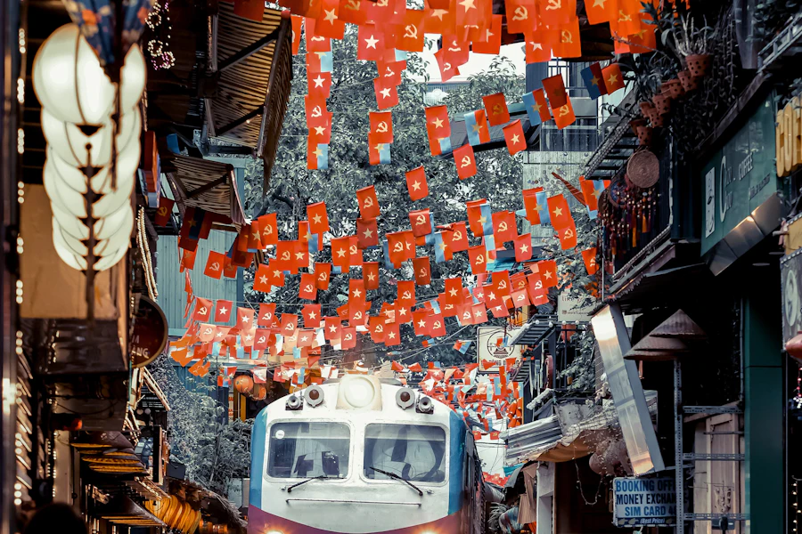 Un train passe entre les cafés de la rue du train
