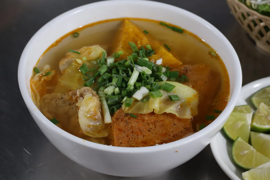 Un bol de soupe de nouilles vietnamienne aux herbes fraîches