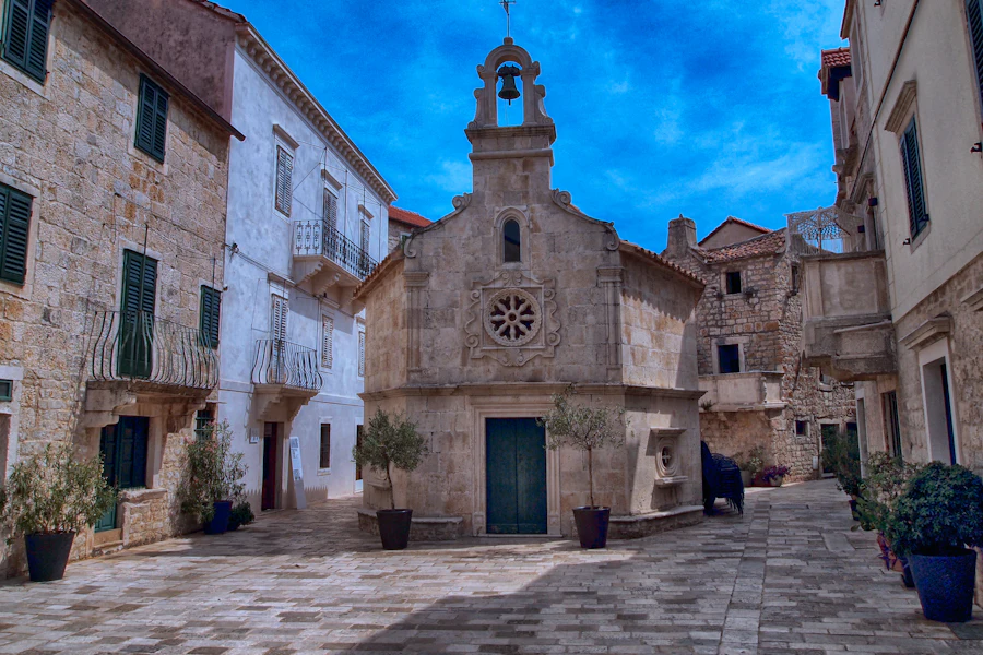 Une église de pierre sur une place de Jelsa