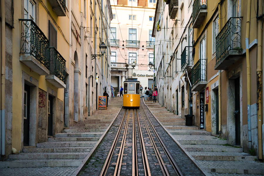 Un funiculaire jaune dans une rue en pente qui monte vers le Bairro Alto