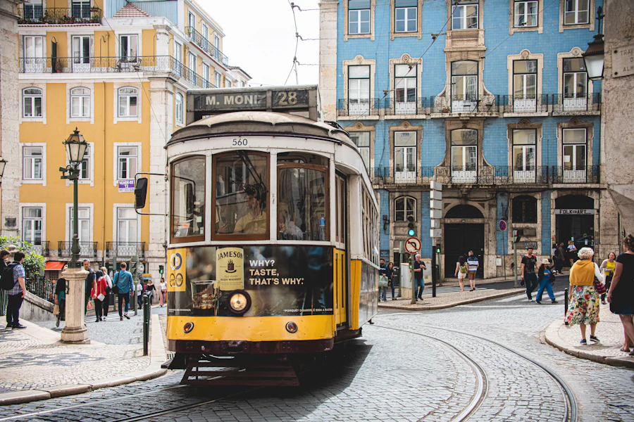 Un tramway jaune dans une rue de Lisbonne bordée de façades colorées