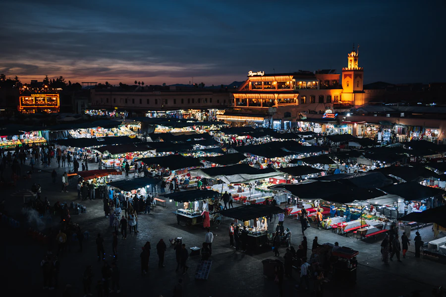 La place Jemaa el-Fna illuminée par les stands, à la tombée de la nuit