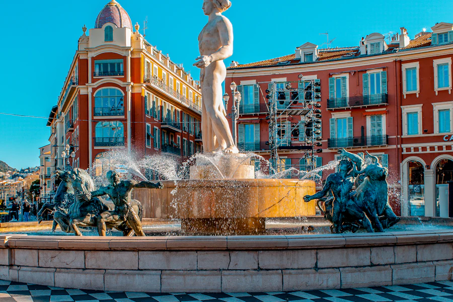 La fontaine du Soleil et les façades rouges de la place Masséna