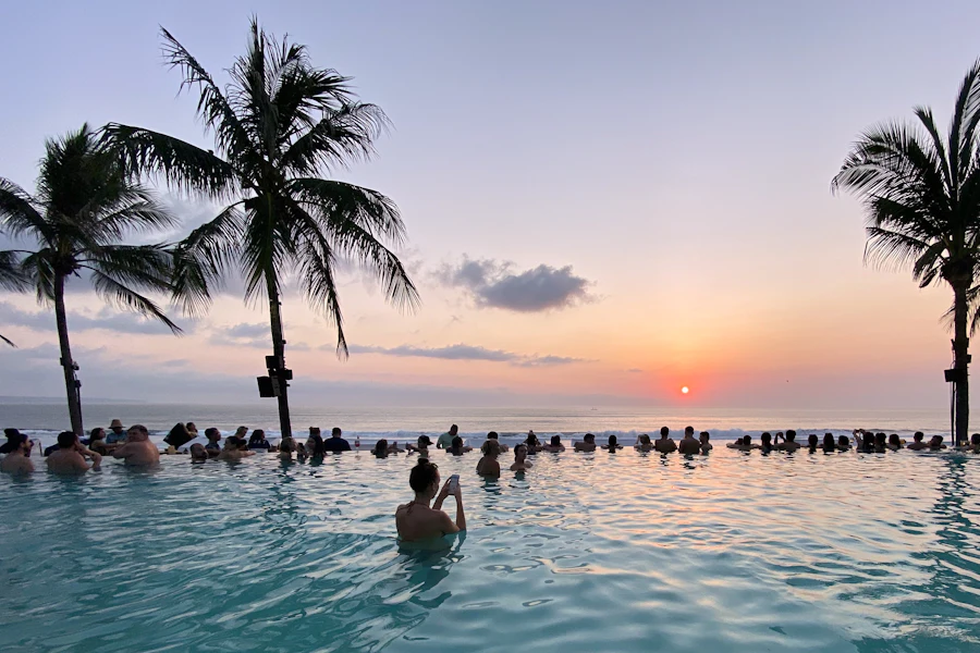 Une piscine entre les cocotiers face à l'océan
