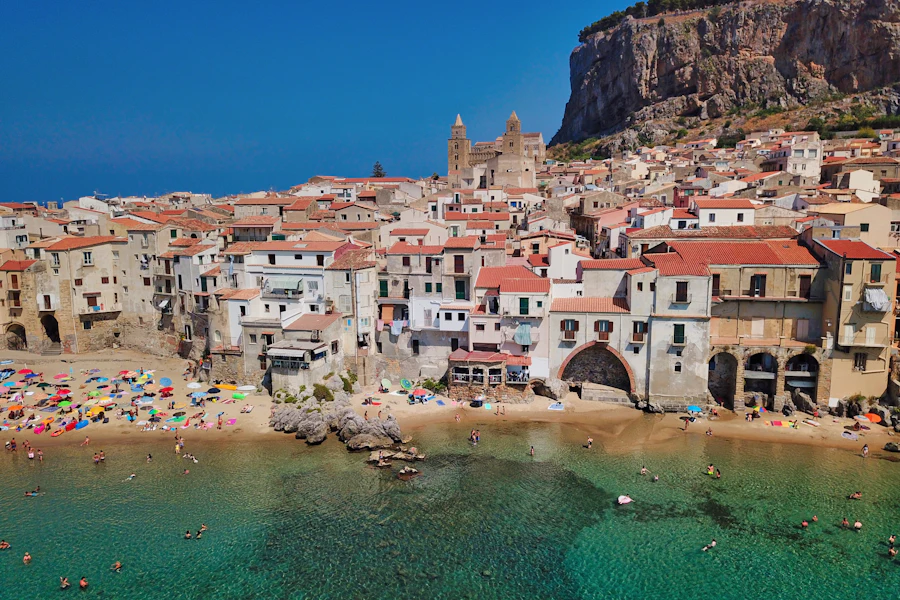 Les maisons de Cefalù au bord de l'eau, sous le rocher