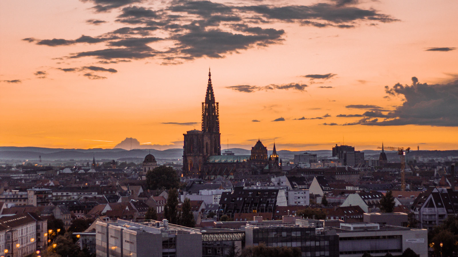 La flèche de la cathédrale au-dessus des toits de Strasbourg, au coucher du soleil