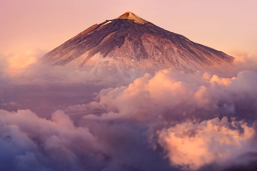 Le cône du Teide émergeant des nuages au coucher du soleil