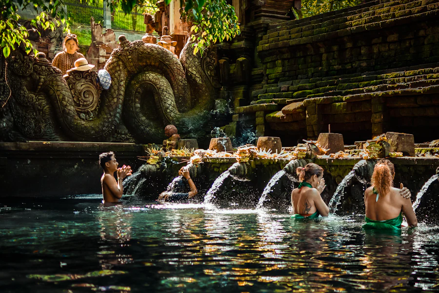 Des fidèles sous les fontaines des bassins sacrés de Tirta Empul