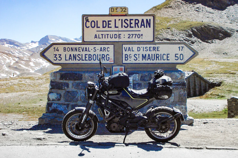 Une moto devant le panneau du col de l'Iseran